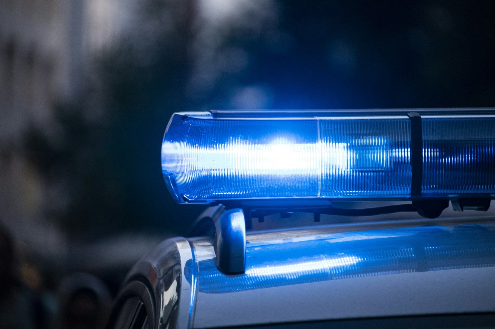 Giroflex azul aceso no teto de uma viatura policial à noite